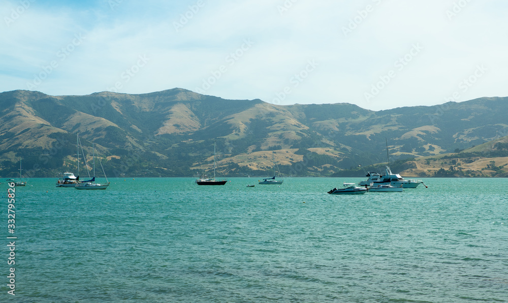 Boats on sea next to land at Akaroa in New Zealand Boats on sea next to land at Akaroa in New Zealand