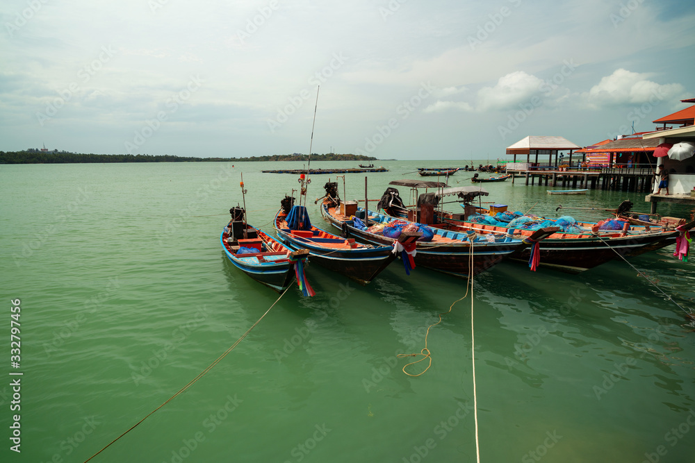 Longtail boat with coastal fishing village at koh rat suratthani Thailand.