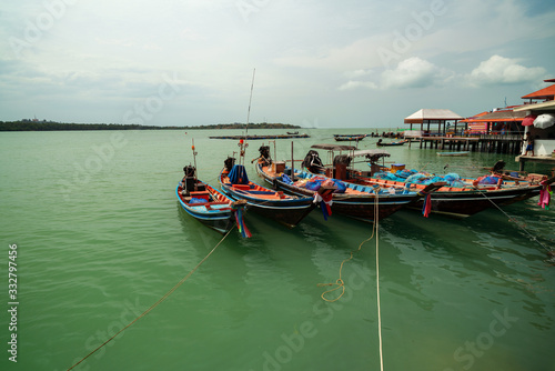Longtail boat with coastal fishing village at koh rat suratthani Thailand.