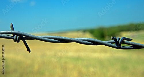 Strong City, Kansas. USA, May 11, 2014 Barbed wire, also known as barb wire, less often bob wire or, in the southeastern United States, bobbed wire, is a type of steel fencing wire constructed with s