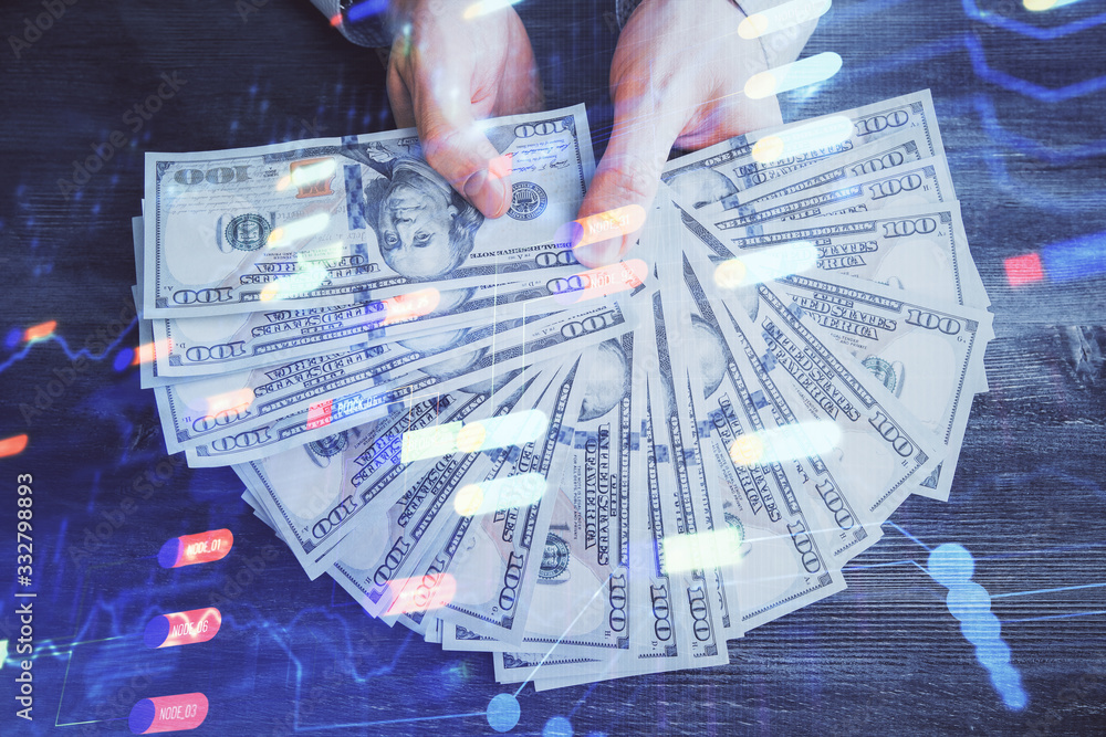 Multi exposure of technology drawing hologram and us dollars bills and man hands. Data concept Multi exposure of technology drawing hologram and us dollars bills and man hands. Data concept
