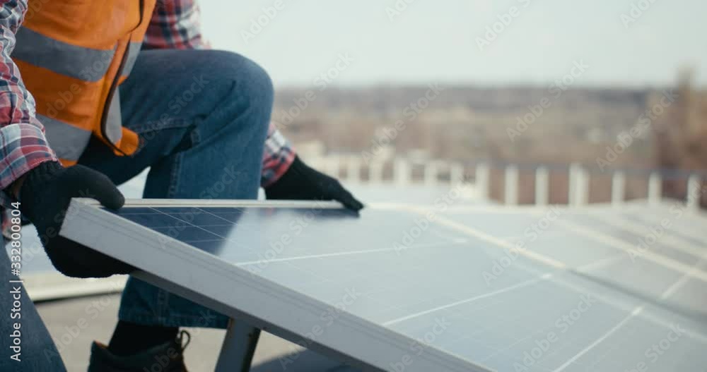 Technicians installing solar panels on metal stand