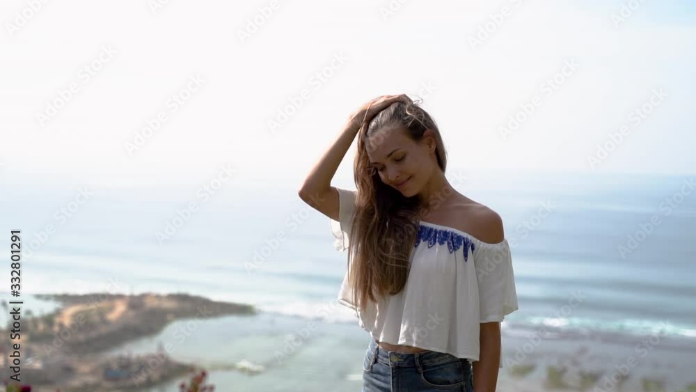 Outdoor summer portrait of young pretty woman looking to the ocean at tropical beach Outdoor summer portrait of young pretty woman looking to the ocean at tropical beach