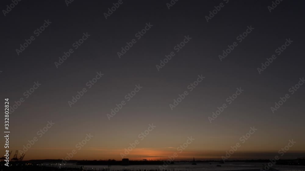 Distant urban sunset skyline. The sun already settled. Warm orange magic hour lighting. The frame consist mostly of sky. Distant urban sunset skyline. The sun already settled. Warm orange magic hour lighting. The frame consist mostly of sky.