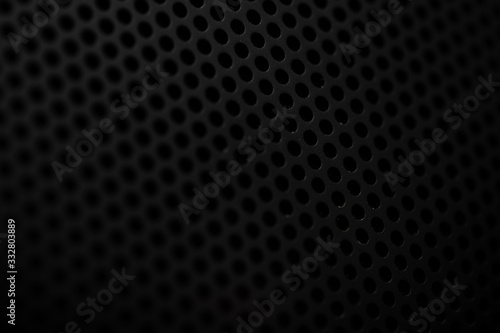 Black metal texture with round holes. Industrial background.