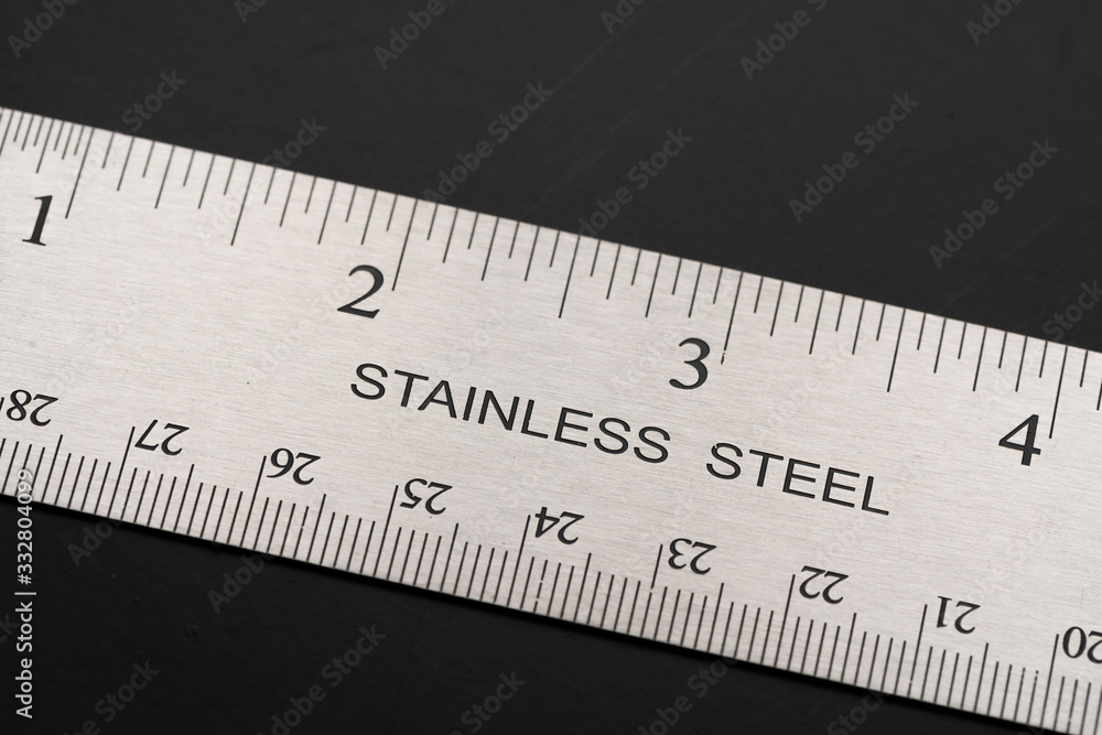 Metal ruler on a black leather isolated background with black numbers and scale. Show scale in black digit. Metal ruler on a black leather isolated background with black numbers and scale. Show scale in black digit.