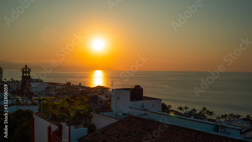Amazing Orange Sunset Over Blue Ocean on a Rooftop view of Old Town in Puerto Vallarta MexicoAmazing Orange Sunset Over Blue Ocean on a Rooftop view of Old Town in Puerto Vallarta Mexico