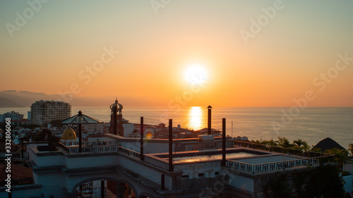 Amazing Orange Sunset Over Blue Ocean on a Rooftop view of Old Town in Puerto Vallarta Mexico