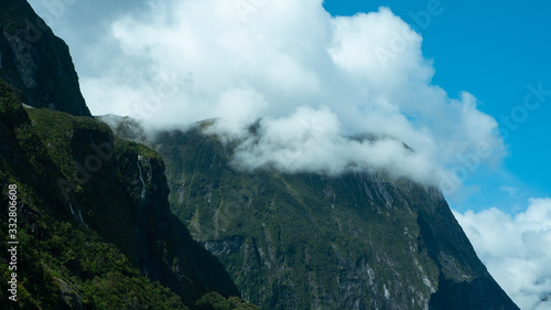 Rolling clouds coming over mountains in a fjord at Milford Sound New Zealand