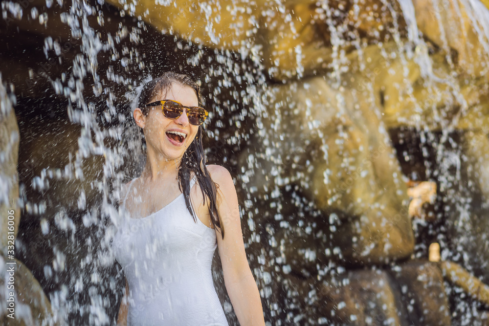 Young joyful woman under the water stream, pool, day spa, hot springs Young joyful woman under the water stream, pool, day spa, hot springs