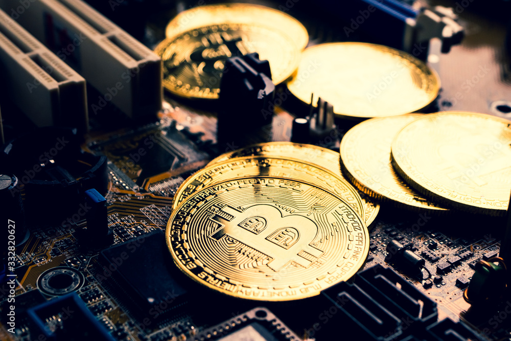 Golden coins with bitcoin symbol on a mainboard. Golden coins with bitcoin symbol on a mainboard.