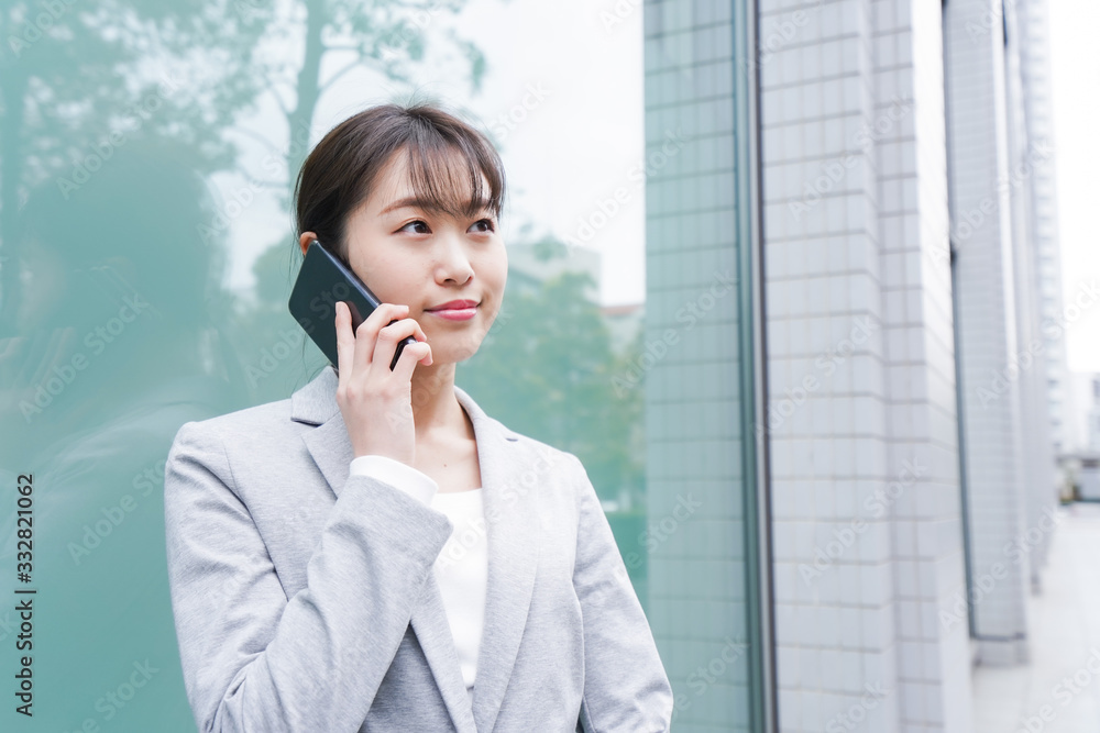 オフィス街で電話をする若いビジネスウーマン