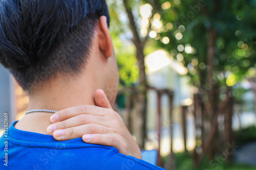 Men have neck pain, shoulder pain, at the park health concept. Trapeziums muscle and holding right hand on muscle, swelling and inflammation of left rotatory cuff muscle