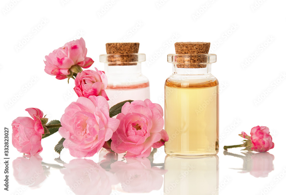 Essential herbal rose oil for aromatherapy bottled for SPA and fresh flowers isolated on white background Essential herbal rose oil for aromatherapy bottled for SPA and fresh flowers isolated on white background