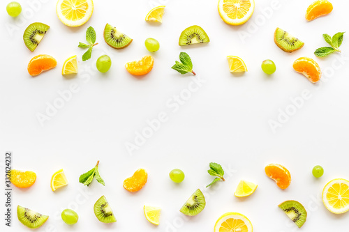 Fototapeta Naklejka Na Ścianę i Meble -  Slices fruites frame. Fruit salad concept with citruses, aplle and kiwi on white background top-down copy space