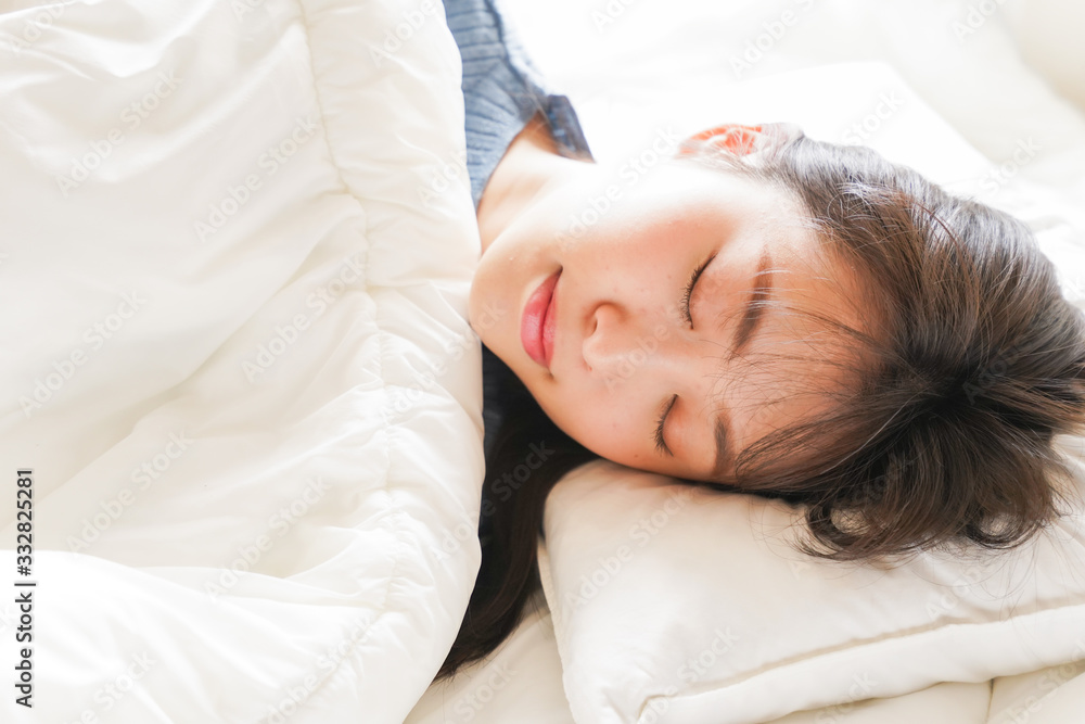 布団に入って睡眠を取る若い女性 布団に入って睡眠を取る若い女性