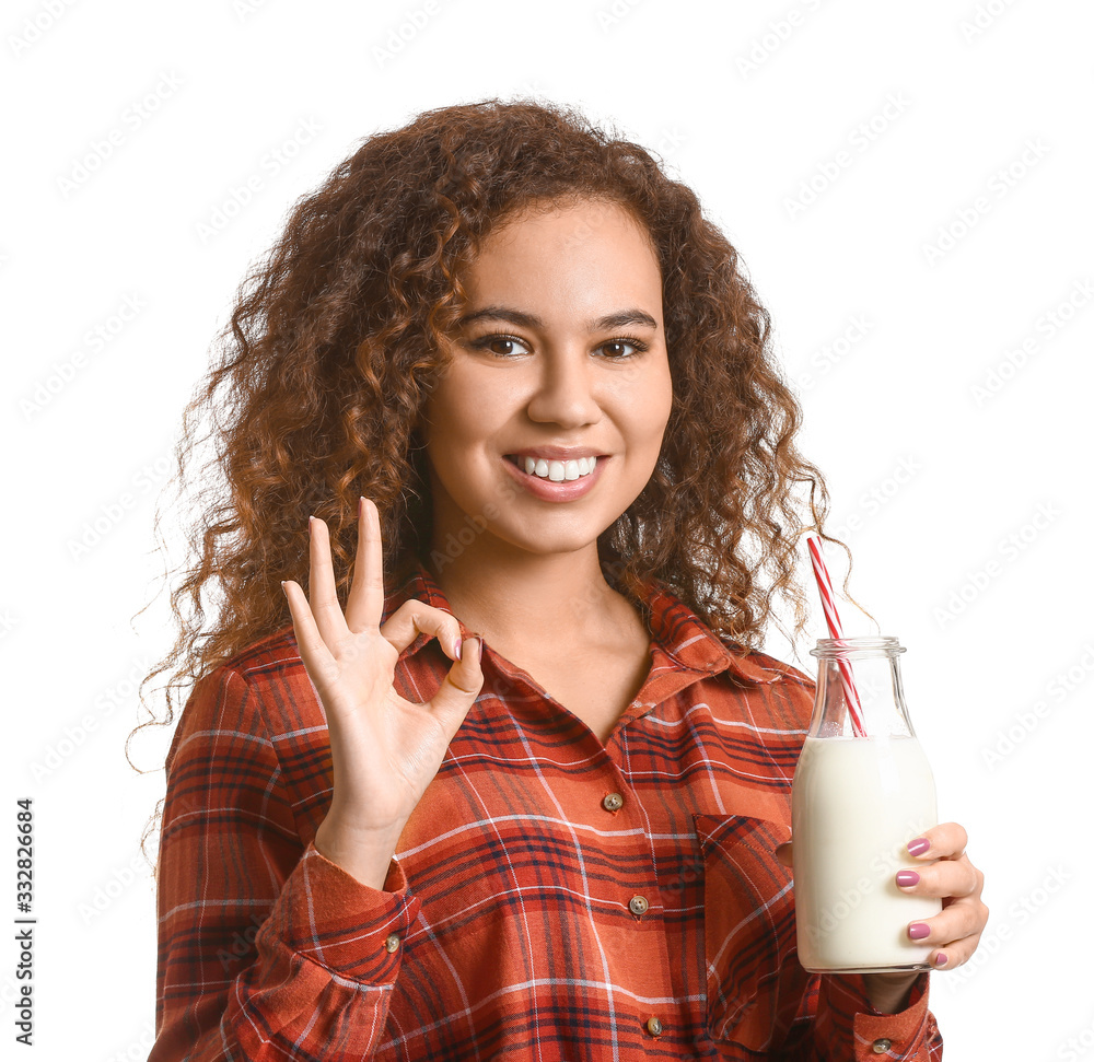 Young African-American woman with milk showing OK on white background Young African-American woman with milk showing OK on white background