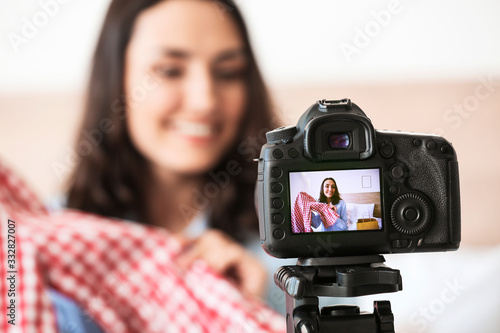 Female fashion blogger recording video at home