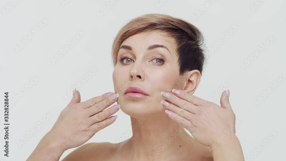 Close-up of middle aged mature woman over white bacjground. Portrait of mature lady. Plastic surgery, beauty injections and cosmetology. Close-up of middle aged mature woman over white bacjground. Portrait of mature lady. Plastic surgery, beauty injections and cosmetology.