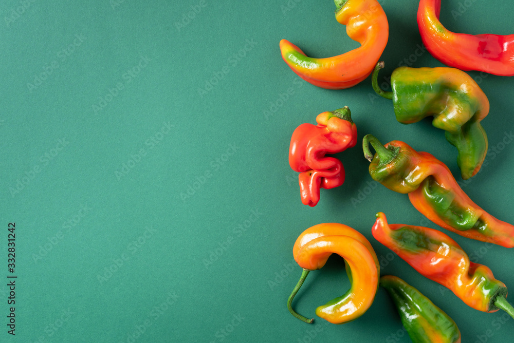 Ugly bell pepper on green background. Concept of zero waste production. Top view. Copy space. Non gmo vegetables Ugly bell pepper on green background. Concept of zero waste production. Top view. Copy space. Non gmo vegetables