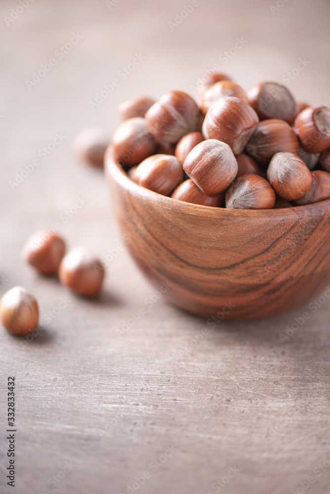 Hazelnuts in wooden bowl on wood textured background. Copy space. Superfood, vegan, vegetarian food concept. Macro of hazelnut, selective focus. Healthy snack. Hazelnuts in wooden bowl on wood textured background. Copy space. Superfood, vegan, vegetarian food concept. Macro of hazelnut, selective focus. Healthy snack.