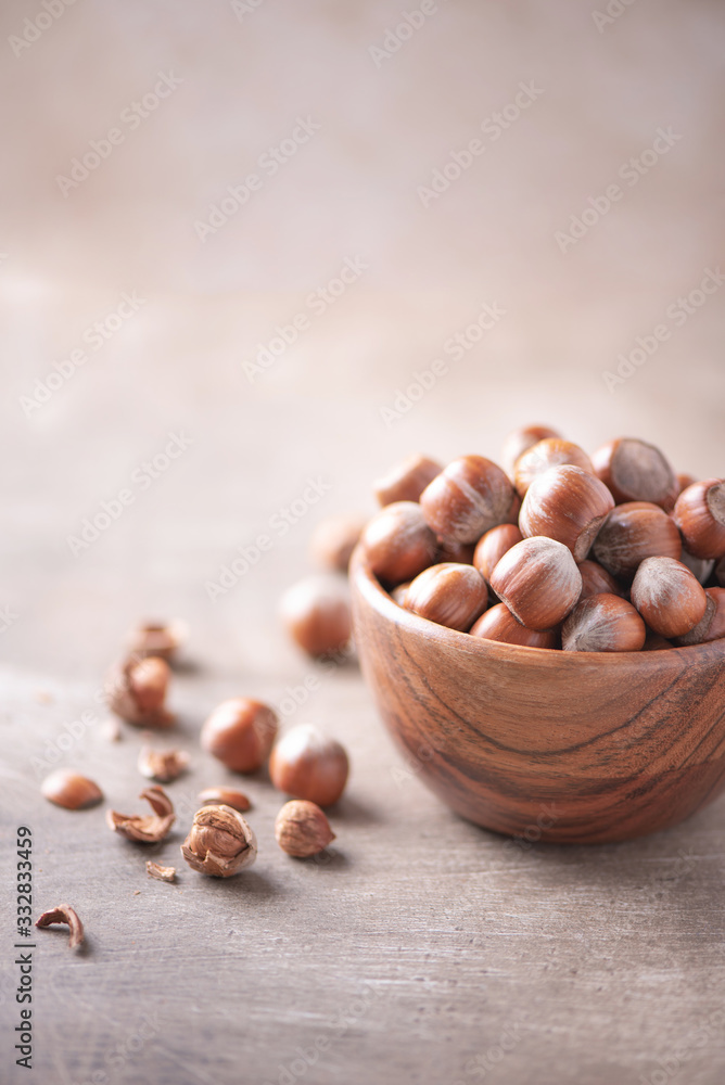 Hazelnuts in wooden bowl on wood textured background. Copy space. Superfood, vegan, vegetarian food concept. Macro of hazelnut, selective focus. Healthy snack. Hazelnuts in wooden bowl on wood textured background. Copy space. Superfood, vegan, vegetarian food concept. Macro of hazelnut, selective focus. Healthy snack.