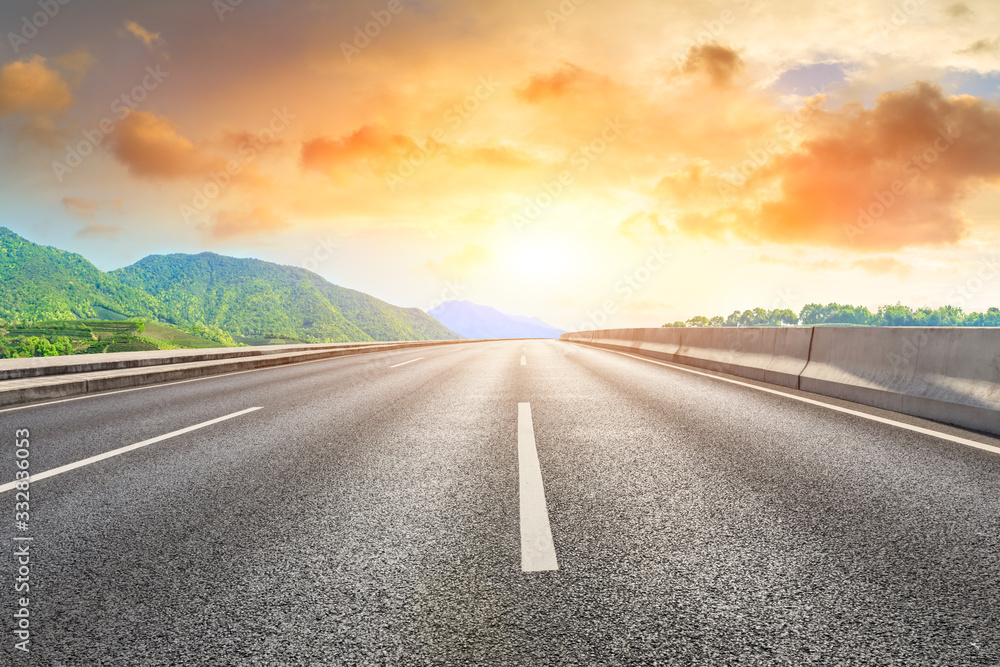 Fototapeta premium Empty asphalt road and green mountain nature landscape at sunset.