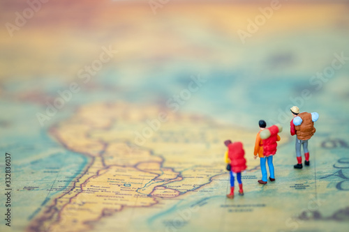 Miniature people: Group of backpacker on vintage world map using as business trip traveler adviser agency or explorer on earth background concept.