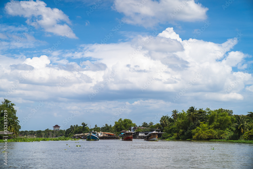 Three towing boats are pulling sand carriers in the middle of the river on a clear day. Three towing boats are pulling sand carriers in the middle of the river on a clear day.