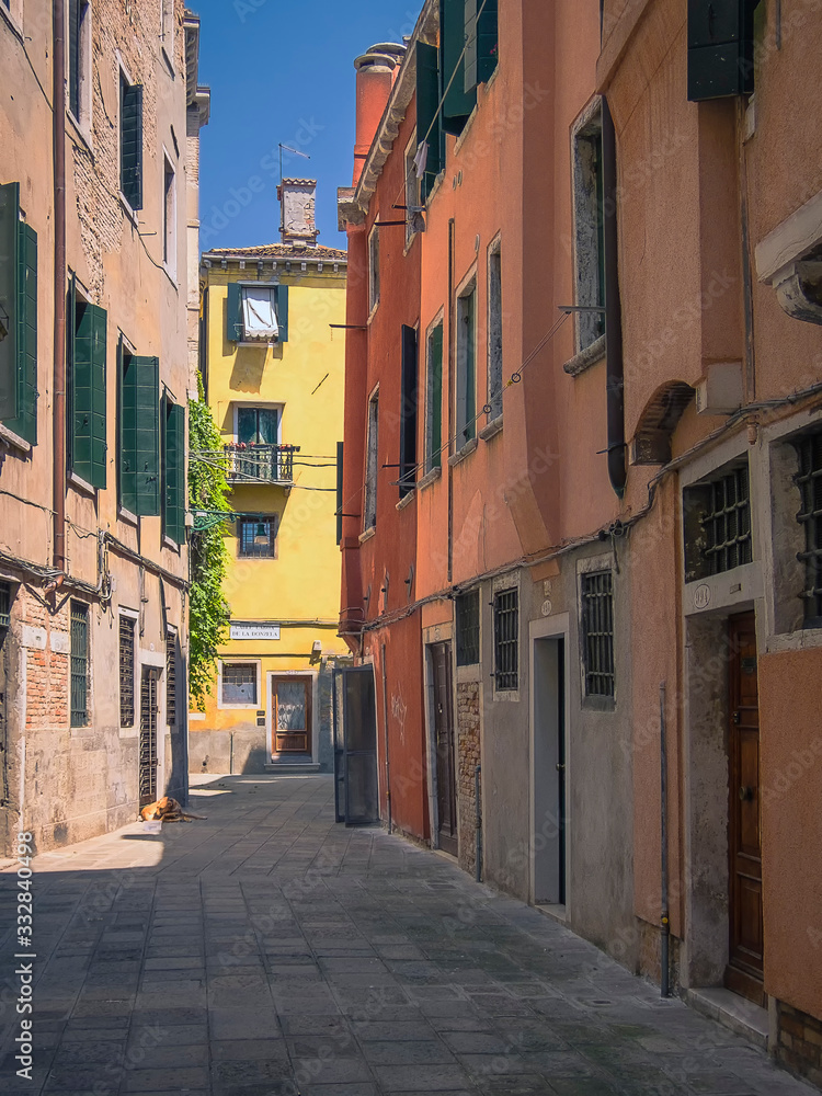 One of the many little side streets lined with colourful buildings in Venice, Italy