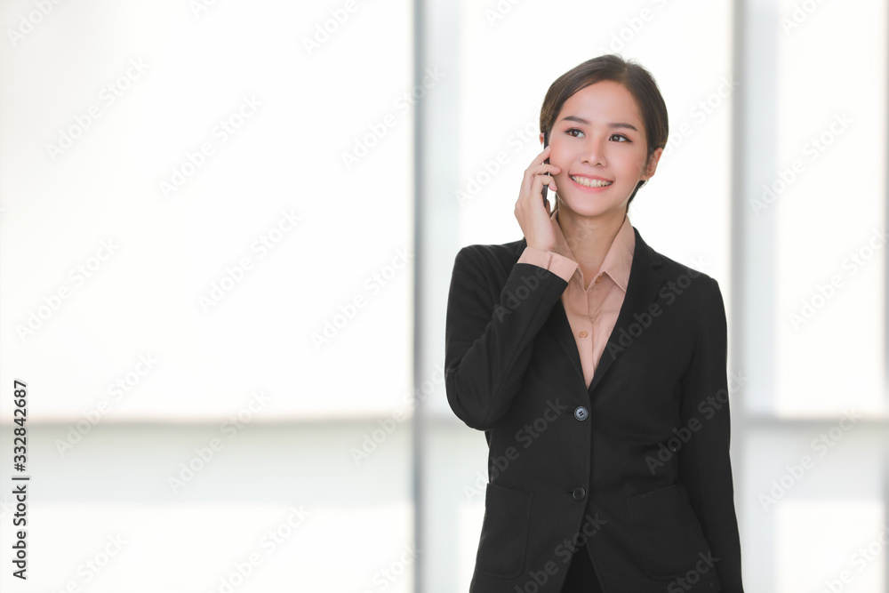 Businesswoman talking to smartphone in office.. Businesswoman talking to smartphone in office..