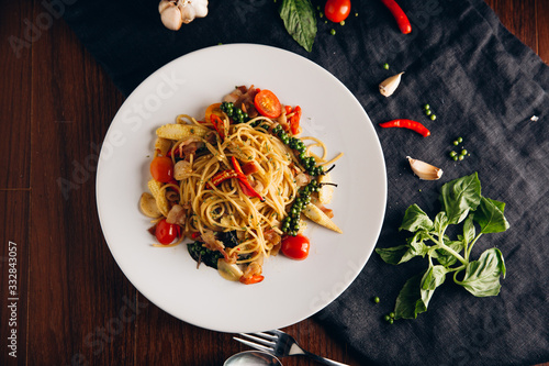 Spicy Drunken Spaghetti. Add ham, garlic, pepper, fresh chilies, baby corn on a white plate. Look from above.