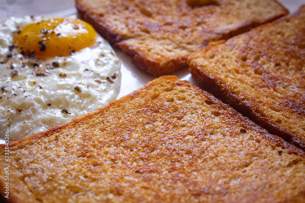Butter toasted wheat bread with bulls eye egg. Sunny side up egg with bread toast.