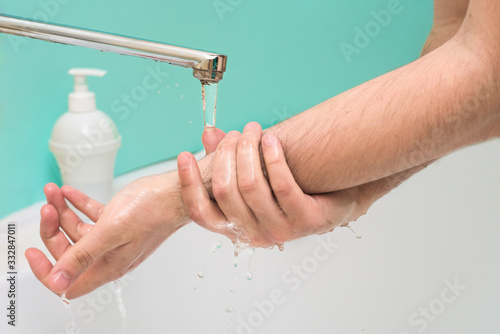 wash your hands with disinfectant soap during a coronavirus infection. close-up of a hand in soap foam. antibacterial treatment of the hands. on a blue background