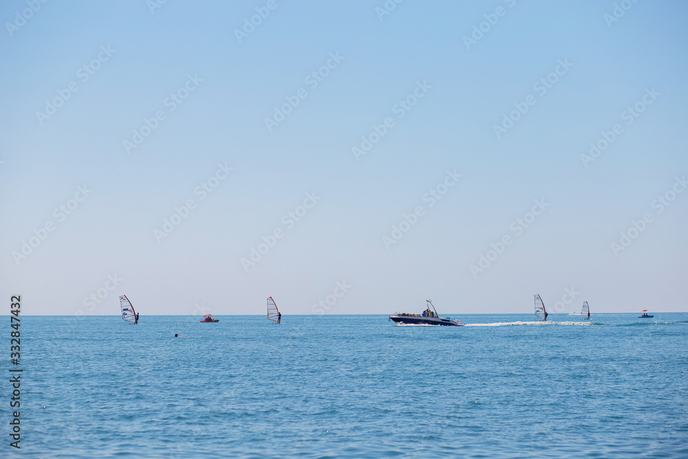 Windsurfers and a large pleasure boat plow the expanses of the Black Sea. Water vessels, water sports Windsurfers and a large pleasure boat plow the expanses of the Black Sea. Water vessels, water sports
