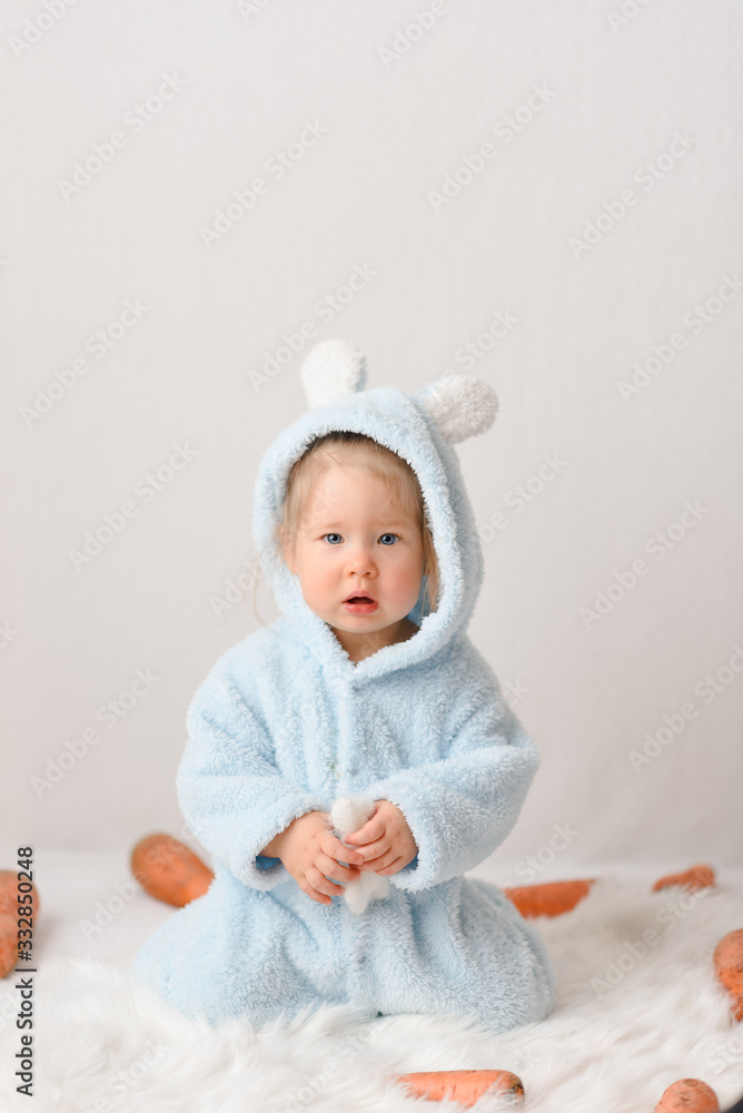 A little girl in a rabbit costume is surprised at the price of a carrot. A little girl in a rabbit costume is surprised at the price of a carrot.