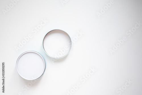 Closed cosmetics jar and lid on a white background top view with copy space