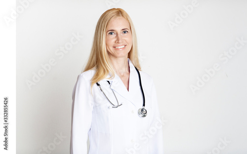 Happy middle-aged woman doctor posing in uniform
