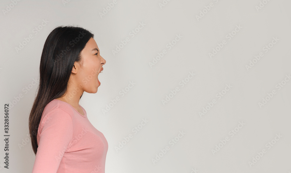 Side view of asian girl screaming towards copy space Side view of asian girl screaming towards copy space