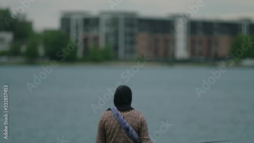 Woman fishing in Hijab on Detroit River photo