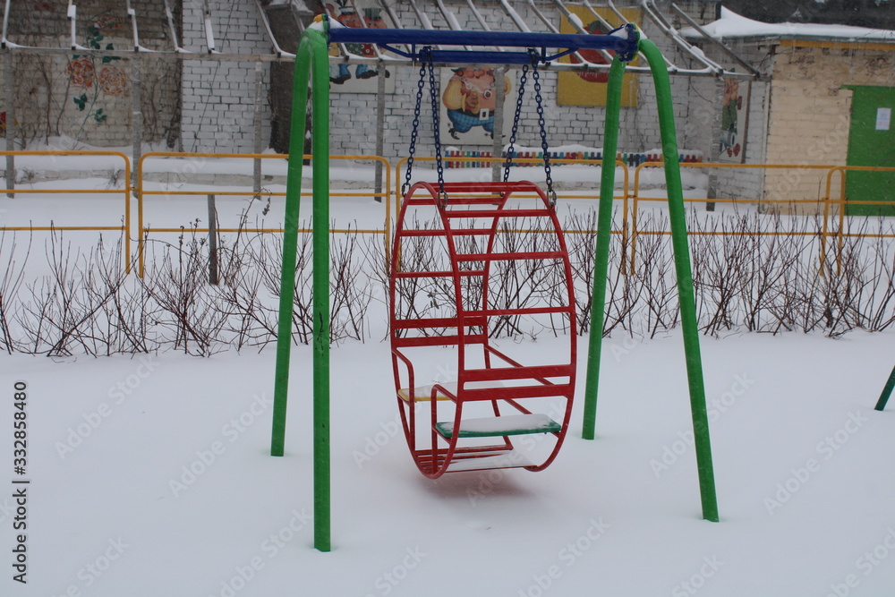 children's Playground in winter in the snow swing children's Playground in winter in the snow swing