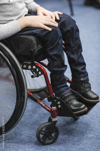 Details of an ill disabled young boy in a wheelchair.