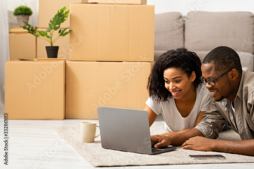 Millennial couple searching design project on laptop