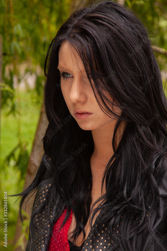 Young woman outside wearing a black leather jacket Young woman outside wearing a black leather jacket