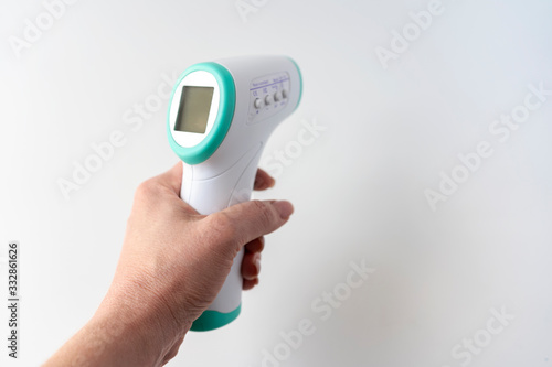 female hand holds a thermometer body temperature control, on a white background, close-up, space for text