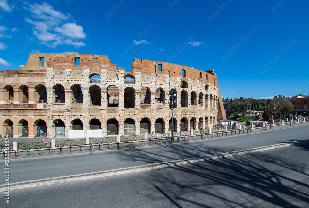 Obraz premium Following the coronavirus outbreak, the italian Government has decided for a massive curfew, leaving even the Old Town, usually crowded, completely deserted. Here in particular the Colosseum