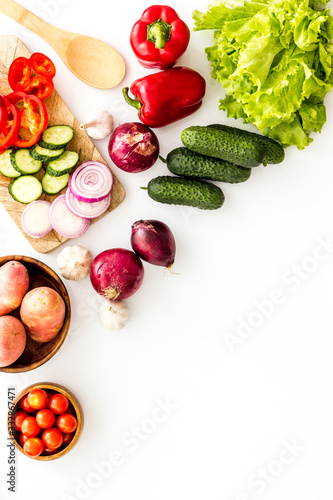 Autumn harvest. Vegetables - potato,cucumber, corn, greenery - frame on white background top-down copy space