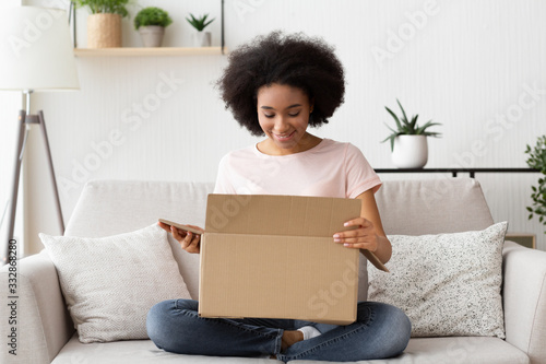 Girl with pleasure opens a box from online store