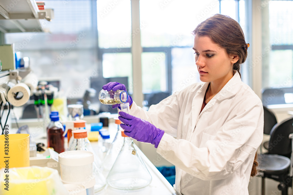 Llaboratory assistant pours liquid into test tube Llaboratory assistant pours liquid into test tube