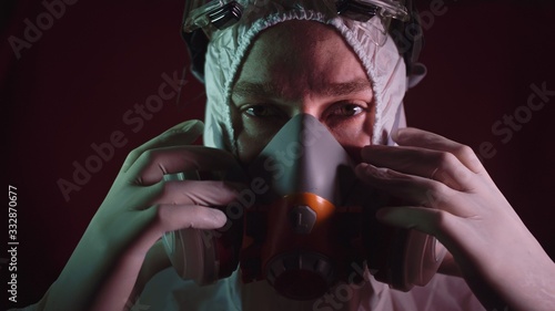 Man in protective costume suit, gas protect medical antibacterial antiviral spray paint mask. Doctor health worker in respirator. Concept health virus coronavirus epidemic. Radiation Nuclear war. photo